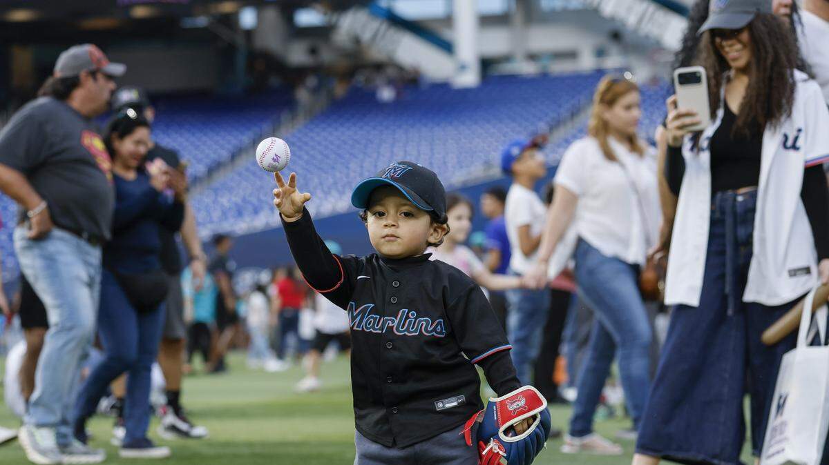 El niño de dos años Benjamín Cabrera-Carrión lanza una pelota durante el Festival del Fanático, celebrado el 7 de febrero de 2026 en el loanDepot park en Miami. 