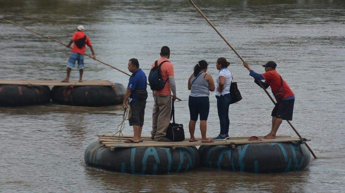 Gupo de migrantes atraviesa en balsa el río Suchiate, para cruzar la frontera entre Guatemala y México.