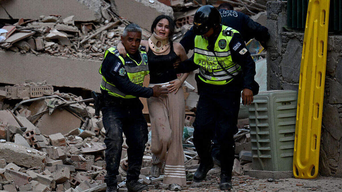 Municipal police officers evacuate an injured victim from a collapsed building following an earthquake in Caracas on June 24, 2026. A magnitude 7.1 earthquake struck Venezuela on Wednesday, the United States Geological Survey (USGS) reported, triggering panic in Caracas, according to AFP journalists. The tremor, which was followed by several aftershocks, was also felt in Colombia.