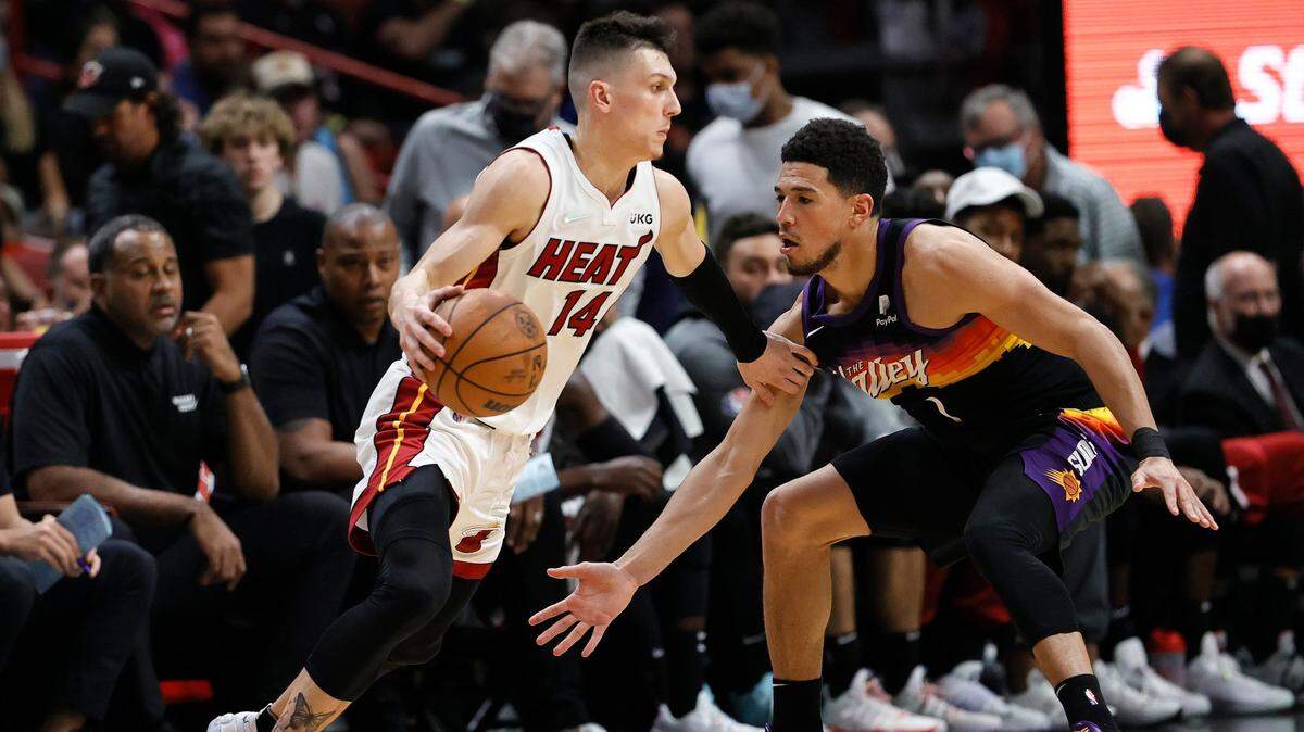 El escolta del Heat Tyler Herro trata de pasar la marca de Devin Booker, de los Suns de Phoenix, en el partido celebrado el 9 de marzo de 2022 en Miami.