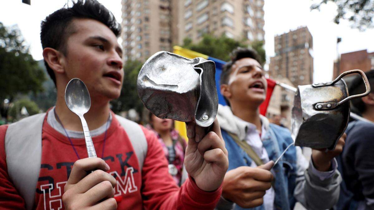 Manifestantes golpean cacerolas en el lugar donde el joven Dilan Cruz fue herido, durante las protestas contra el gobierno colombiano, el martes 26 de noviembre de 2019, en Bogotá. Cruz, de 18 años, falleció el martes dos días después de ser herido en las protestas, convirtiendose en la primera víctima mortal de las manifestaciones.