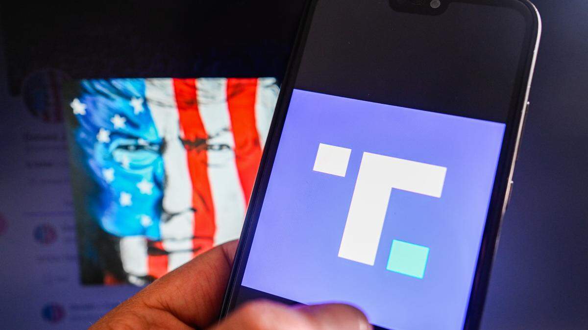 En esta ilustración fotográfica, se muestra el logotipo de Truth Social en un teléfono inteligente con la cuenta de Truth Social Donald Trump de fondo.