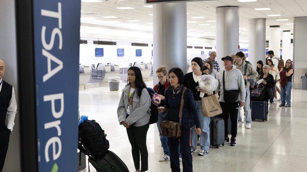 Travelers wait in a TSA PreCheck line at Miami International Airport as summer travel demand begins to rise.