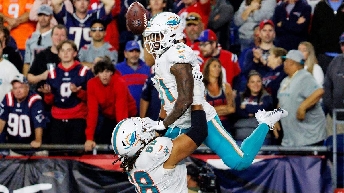 El guard de los Dolphins Robert Hunt carga a Raheem Mostert luego de que el running back anotara un touchdown en el partido ante los Patriots de New England, celebrado el 17 de septiembre de 2023 en en el Gillette Stadium en Foxborough, Massachusetts. 