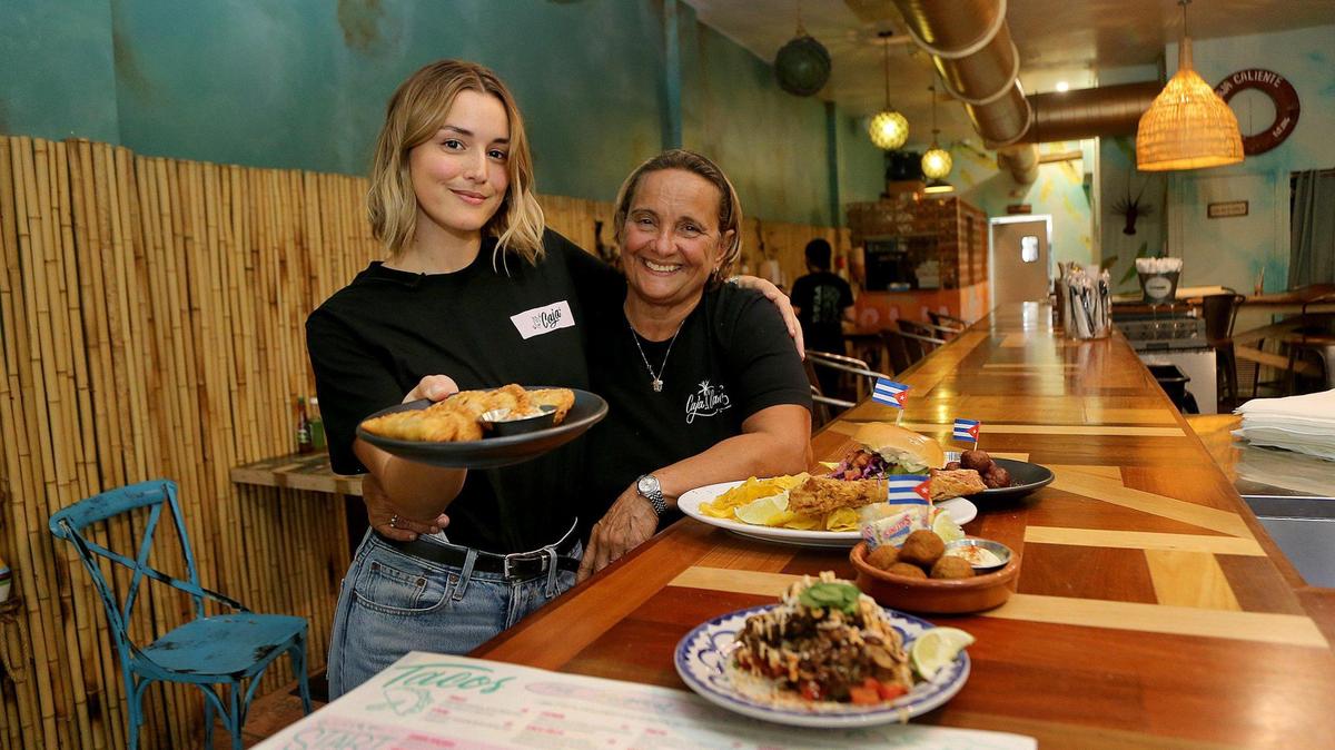 La chef Mónica “Mika” León y su mamá, Lupita Estupiñán, con algunos de los platos del menú de su restaurante Caja Caliente, en Coral Gables, el 18 de septiembre.