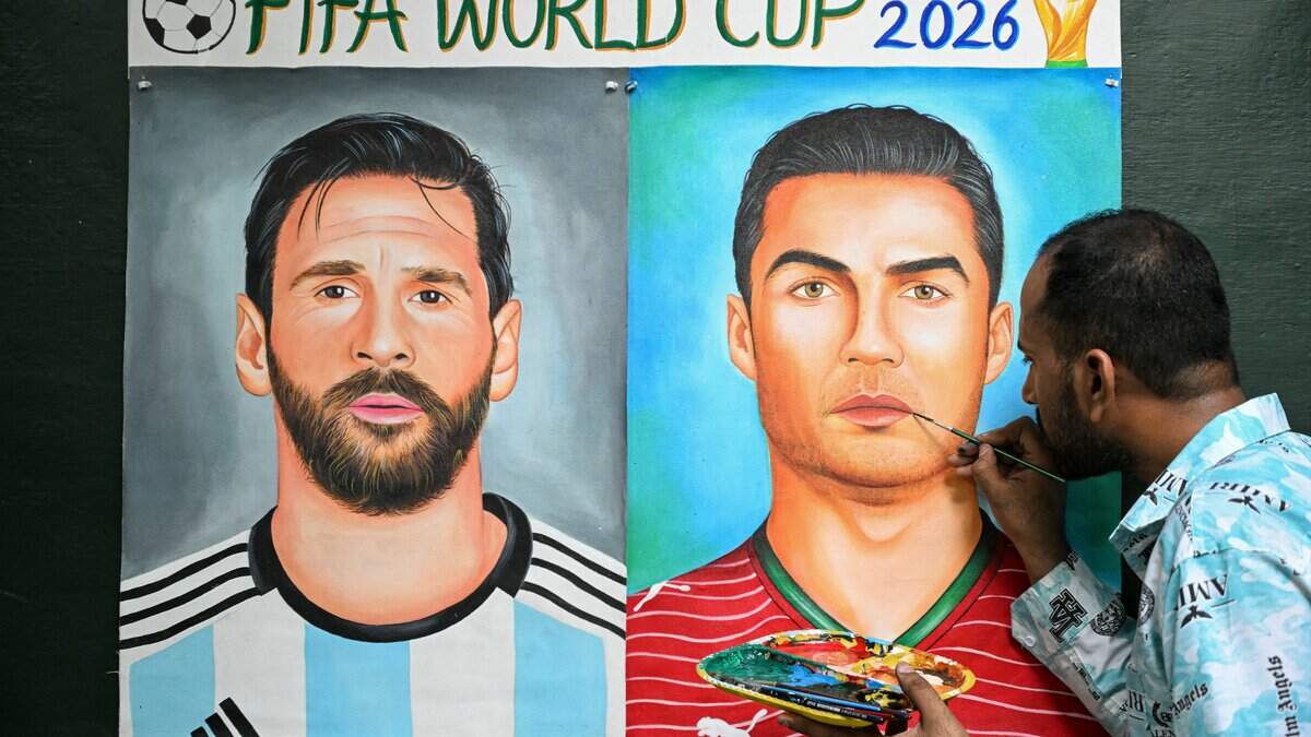 Un artista añade los últimos retoques a una pintura que muestra a los futbolistas Lionel Messi, de Argentina, y Cristiano Ronaldo, de Portugal, en Amritsar, el 11 de junio de 2026, en la víspera del torneo de la Copa Mundial de la FIFA 2026.