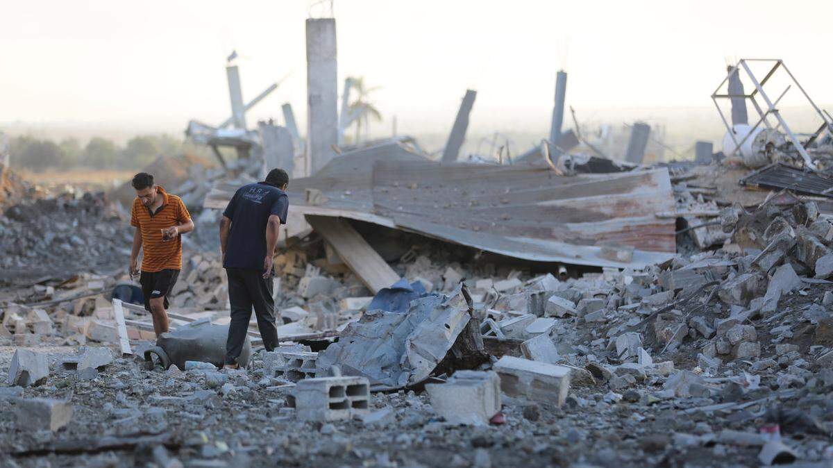 Dos palestinos examinan los escombros de una casa destruida por un bombardeo israelí, en el campo de refugiados Al Bureij, en la región central de Gaza, el martes 24 de septiembre de 2024.