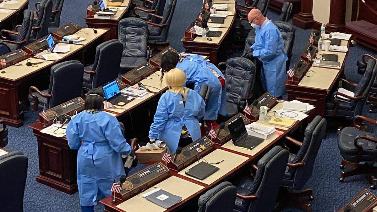 Personal limpia los escritorios de la Cámara de Representantes de la Asamblea Legislativa de Florida luego de que cinco congresistas se autoaislaron a la espera de los resultados de las pruebas de coronavirus el 9 de marzo de 2020.