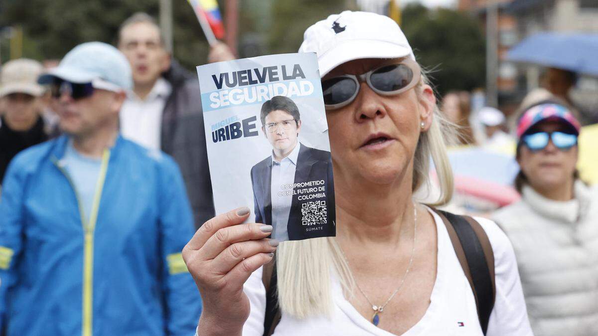 Una mujer sostiene un cartel durante una caminata por la paz y en apoyo al senador Miguel Uribe Turbay este domingo, en Bogotá, Colombia.