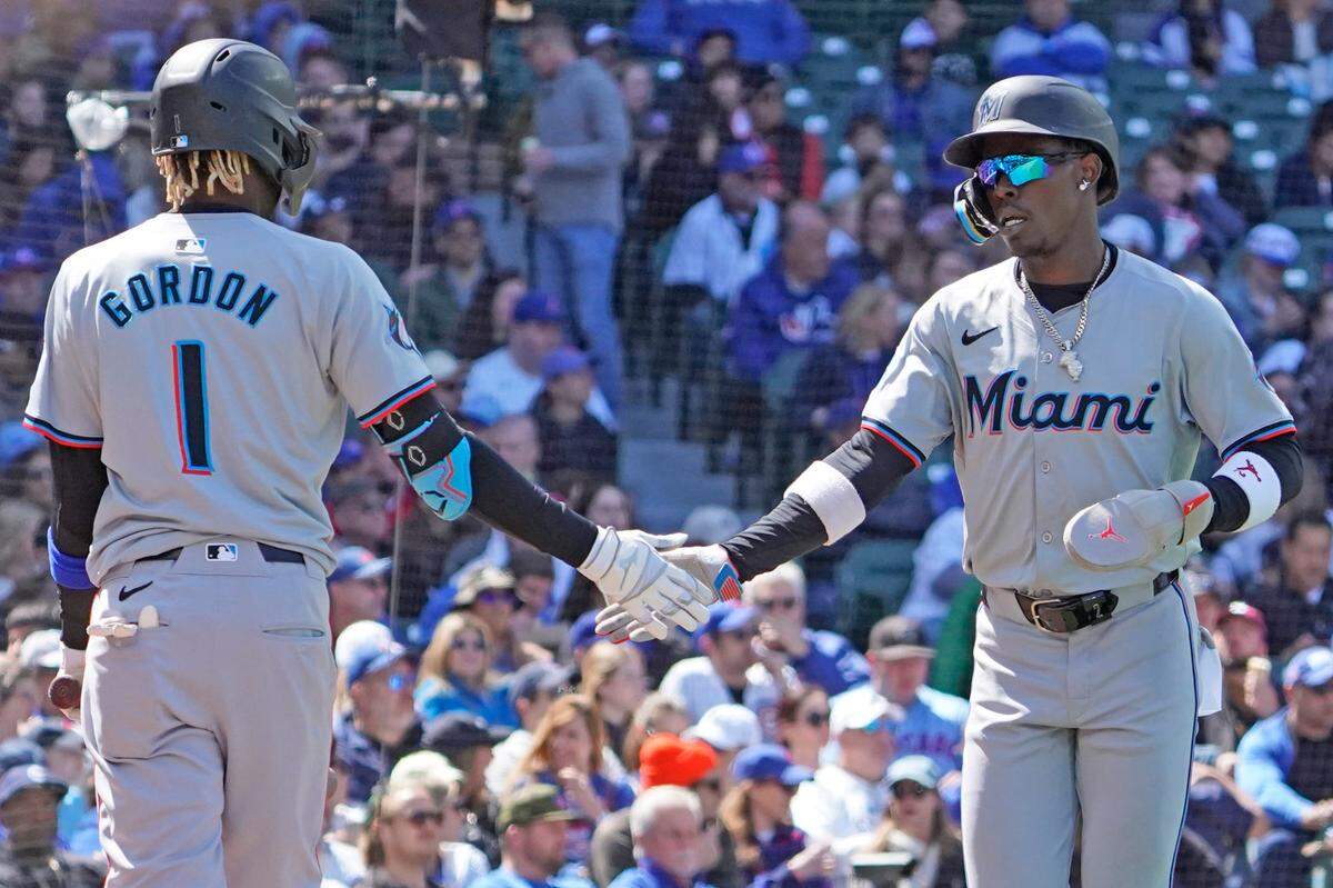 El jardinero de los Marlins de Miami Jazz Chisholm Jr. (der.) recibe el saludo de su compañero de equipo Nick Gordon en el cuarto inning del partido ante los Cachorros, celebrado el 21 de abril de 2024 en el Wrigley Field de Chicago.