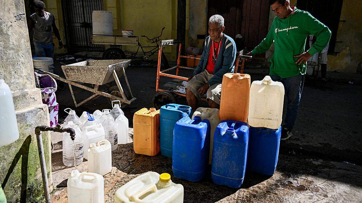 Varias personas hacen fila para llenar sus recipientes de agua en La Habana durante un apagón nacional, el domingo 22 de marzo de 2026. Las autoridades cubanas se movilizaron con urgencia el domingo para restablecer el suministro eléctrico en la isla tras el segundo apagón a nivel nacional en menos de una semana, mientras la red eléctrica enfrenta dificultades debido a una infraestructura envejecida y a un bloqueo petrolero por parte de Estados Unidos.