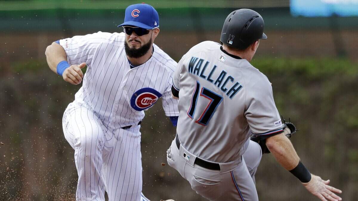 El segunda base de los Cachorros David Bote (izq.) pone out al receptor de los Marlins Chad Wallach en la intermedia, en el sexto inning del partido celebrado el 9 de mayo de 2019 en Chicago.