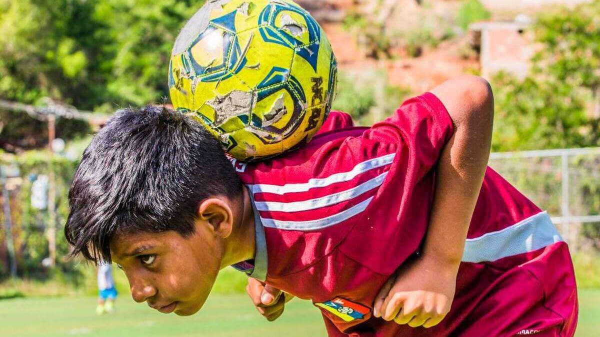 Yoangel Sánchez, de 11 años, demuestra sus habilidades en la cancha de fútbol de Villa Esperanza, Petare, en Caracas. La pelota fue proporcionada por la organización de fútbol Pasión Petare.