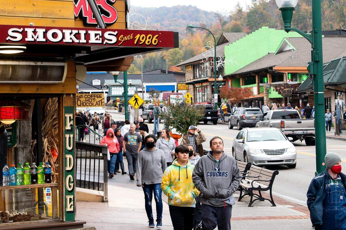 Los turistas caminan por tiendas, restaurantes y atracciones a lo largo de la concurrida Parkway en el centro de Gatlinburg.