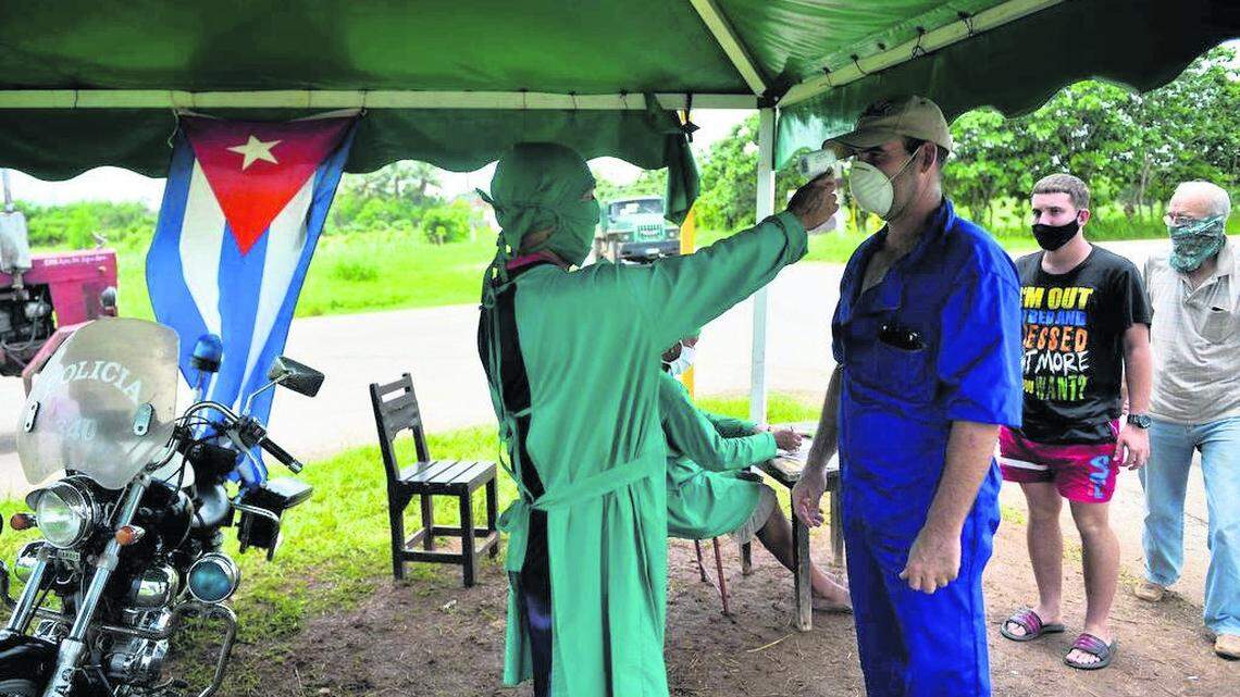 A health worker checks a man’s temperature in San José de las Lajas, Mayabeque province, Cuba, on June 18, 2020.