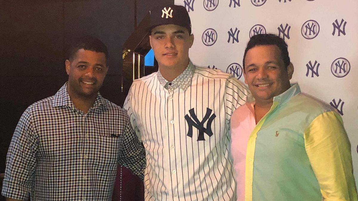 OSIEL RODRIGUEZ (centro) con ejecutivos de los Yankees en Dominicana.