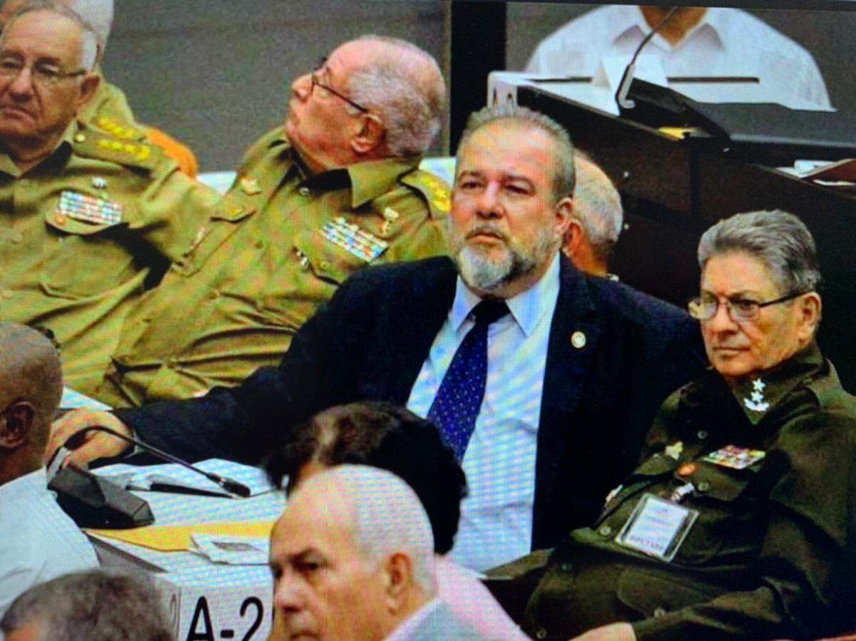 El nuevo Primer Ministro de Cuba, Manuel Marrero, rodeado de militares durante la sesión de la Asamblea Nacional.