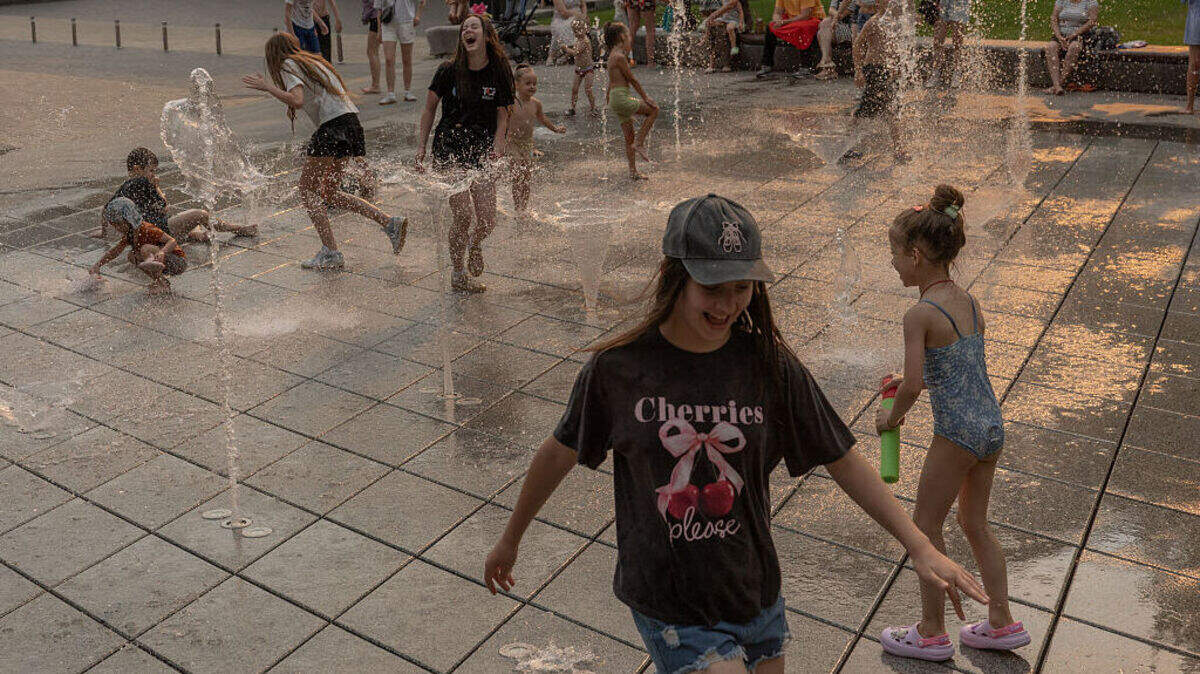 Adolescentes y niños se refrescan jugando en una fuente en Kiev, el lunes 29 de junio de 2026, mientras la ola de calor europea se desplaza hacia el este, hacia los Balcanes y Ucrania, en medio de la invasión rusa de Ucrania.