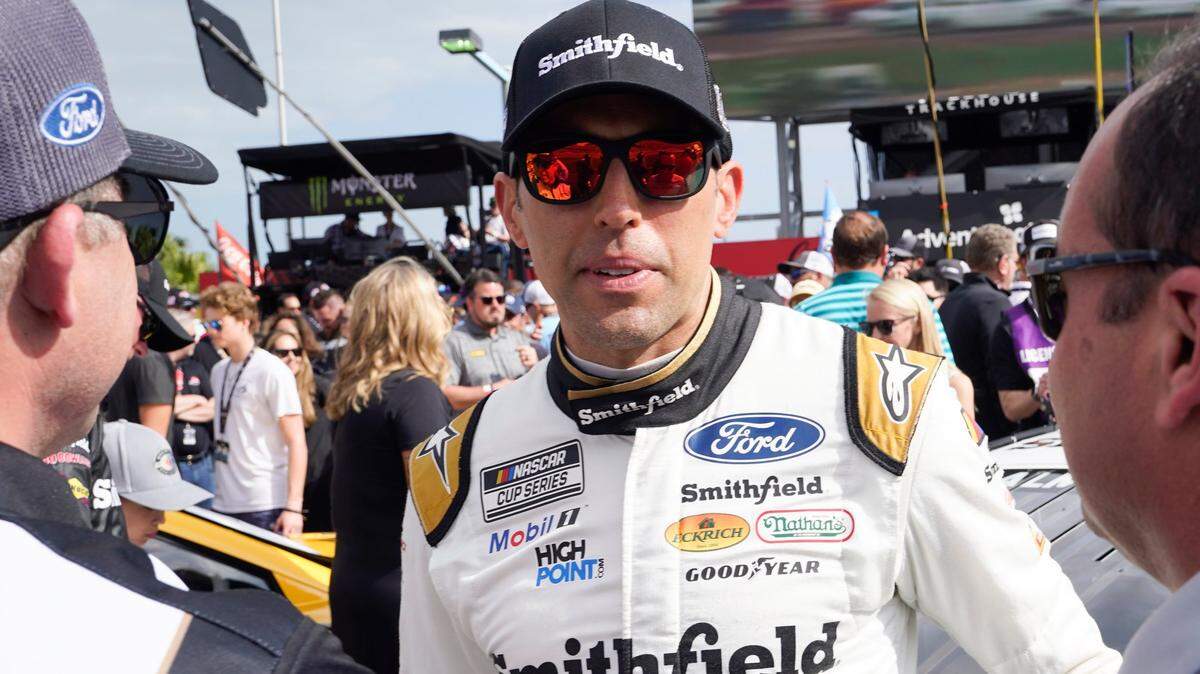Aric Almirola habla con los miembros de su equipo antes del inicio de la carrera Daytona 500 en el Daytona International Speedway, el domingo 19 de febrero de 2023, en Daytona Beach, Florida.