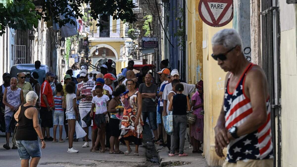 A man wearing a T-shirt featuring the US flag walks down a street in Havana on 30 June 2026. Cuba's Foreign Minister Bruno Rodriguez said in a press conference that months of negotiations with the United States, which is exerting maximum pressure on the island in an attempt to bring about political change, have shown no progress. (Photo by YAMIL LAGE / AFP via Getty Images)