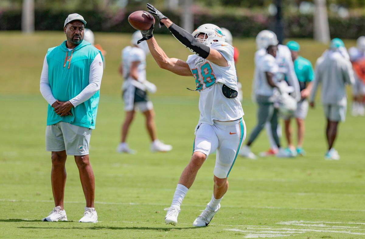 El tight end Mike Gesicki atrapa un pase amte la mirada del coach asistente Jon Embree durante la práctica del equipo en el Baptist Health Training Complex en Miami Gardens, el 22 de septiembre de 2022.