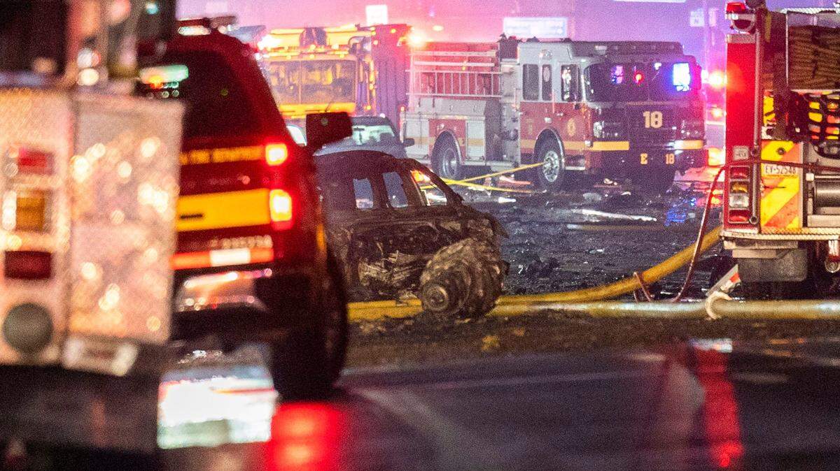 Un automóvil calcinado se encuentra cerca del lugar del accidente aéreo en la cuadra 7200 de Cottman, en el noreste de Filadelfia, el viernes 31 de enero de 2025.