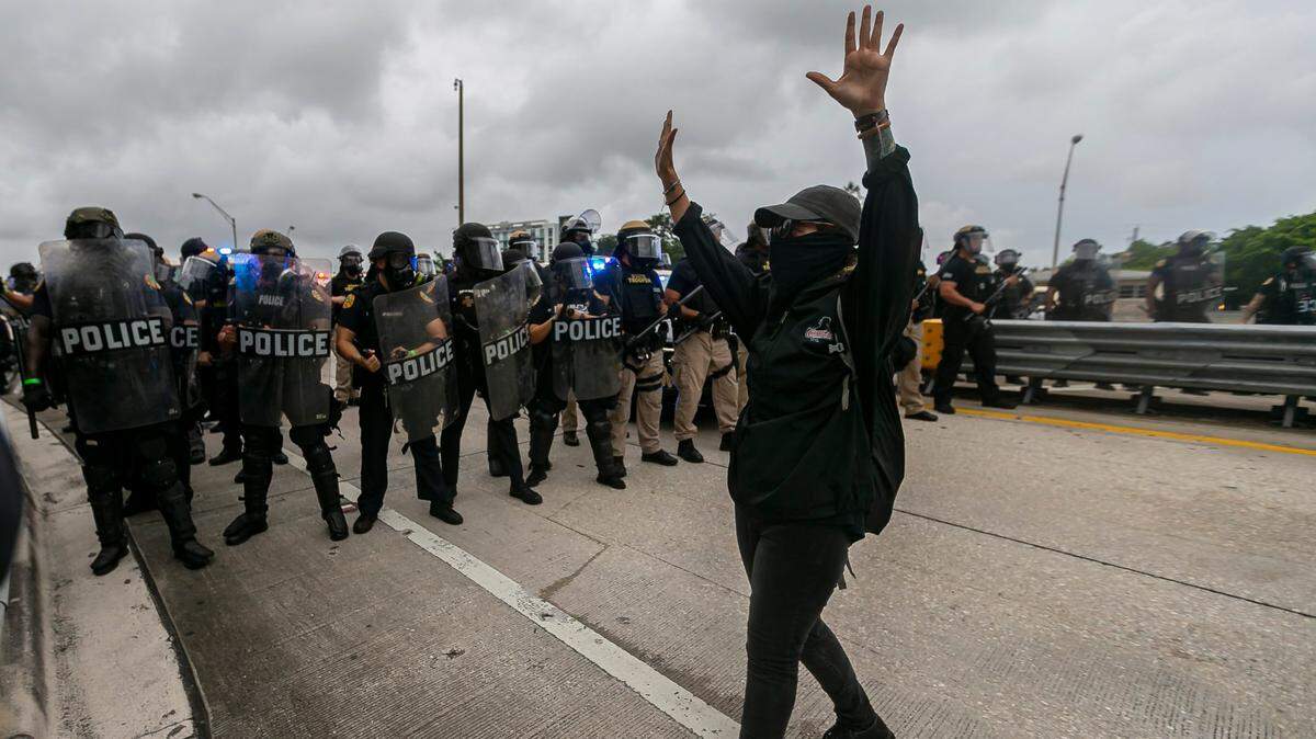 Un manifestante camina frente a una barricada policial durante las protestas por la muerte de George Floyd, el viernes 5 de junio de 2020 en el Viaducto Julia Tuttle de Miami.