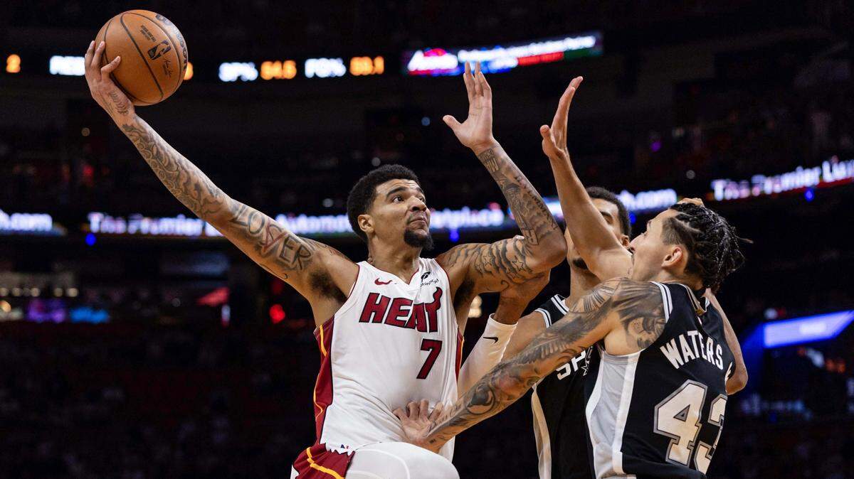 El pívot del Heat Kel’el Ware tira al aro sobre la marca de  Victor Wembanyama (1) y Lindy Waters III (43), de los Spurs de San Antonio, en el partido de pretemporada celebrado el 8 de octubre de 2025 en Miami.
