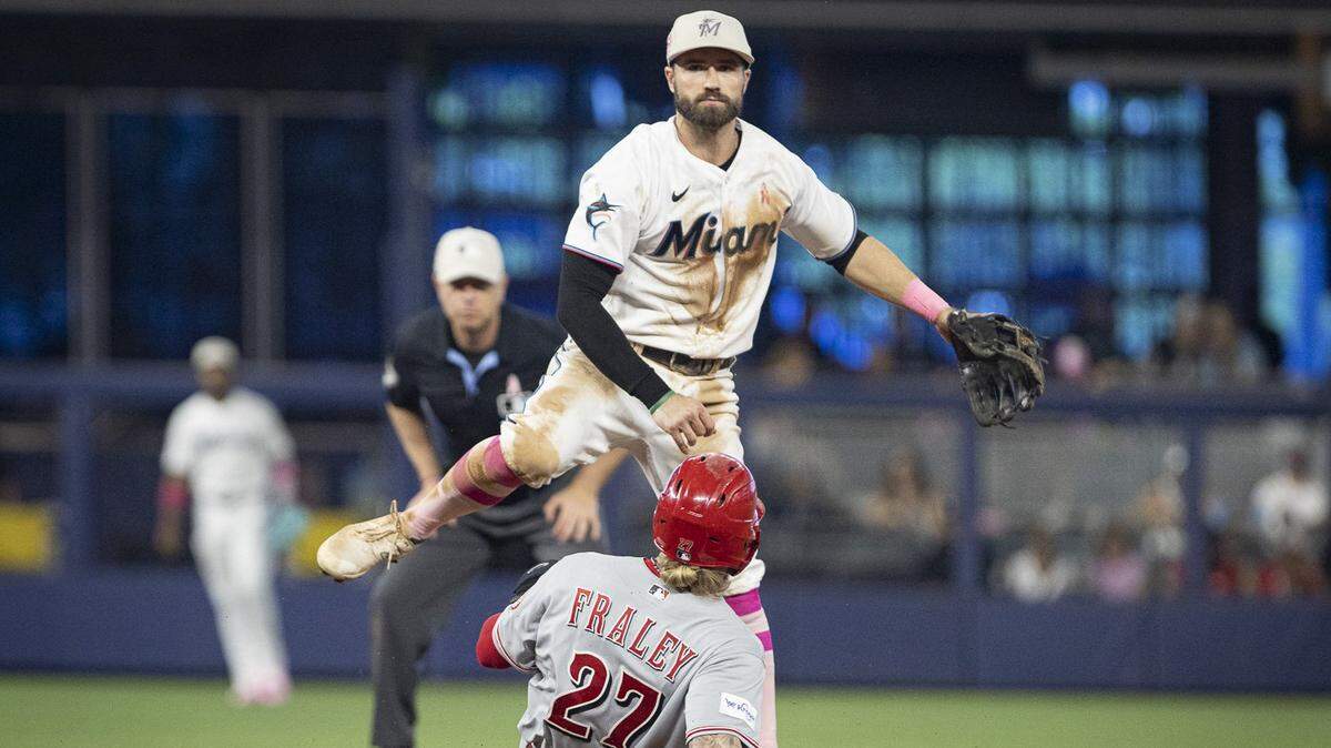 El torpedero de los Marlins Jon Berti tira a primera base en una jugada de doble matanza en el sexto inning del partido ante los Rojos de Cincinnati, celebrado el 14 de mayo de 2023 en Miami.