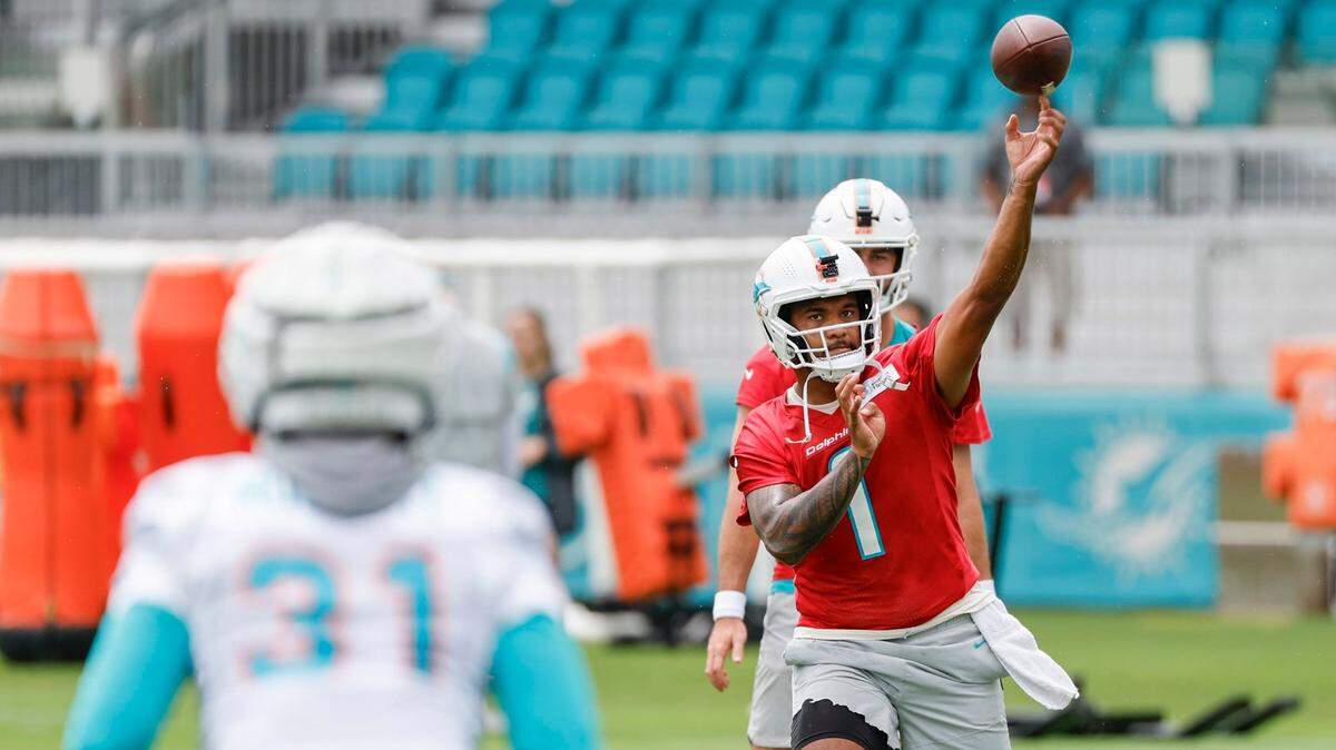 El quarterback de los Dolphins Tua Tagovailoa pasa el ovoide al running back Raheem Mostert, en la práctica celebrada el 26 de julio de 2023 en el Baptist Health Training Complex en Miami Gardens, Florida.