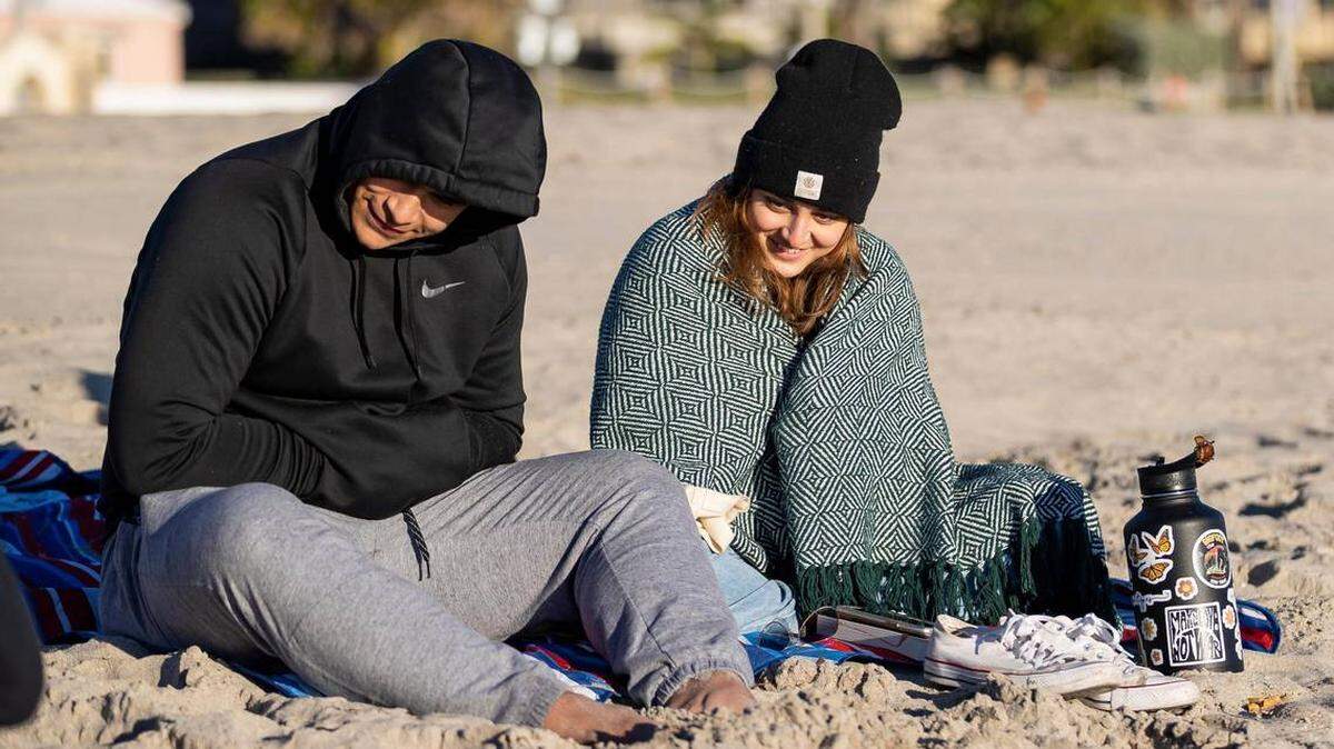 Jordan Stewart y Ashley Rodríguez visitan la playa mientras las temperaturas caen al rango de los 40 grados el sábado 14 de enero de 2023, en Hollywood, Florida. 