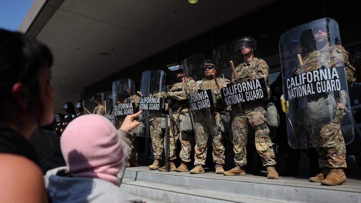 Varias personas se manifiestan en frente de la Guardia Nacional que protege un edificio federal en Los Ángeles, California, el martes 10 de junio de 2025. La decisión del presidente estadounidense, Donald Trump, de enviar a la Guardia Nacional a Los Ángeles para controlar las protestas por las redadas migratorias supone una orden inédita en el país en 33 años. A eso se suma el que el neoyorquino la adoptara sin aprobación del gobernador local, algo no visto desde 1965.