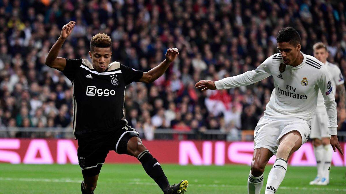 El defensa del Real Madrid Raphael Varane (der.) trata de detener a David Neres, del Ajax, en el partido de vuelta de octavos de final de la Liga de Campeones, celebrado el 5 de marzo de 2019.