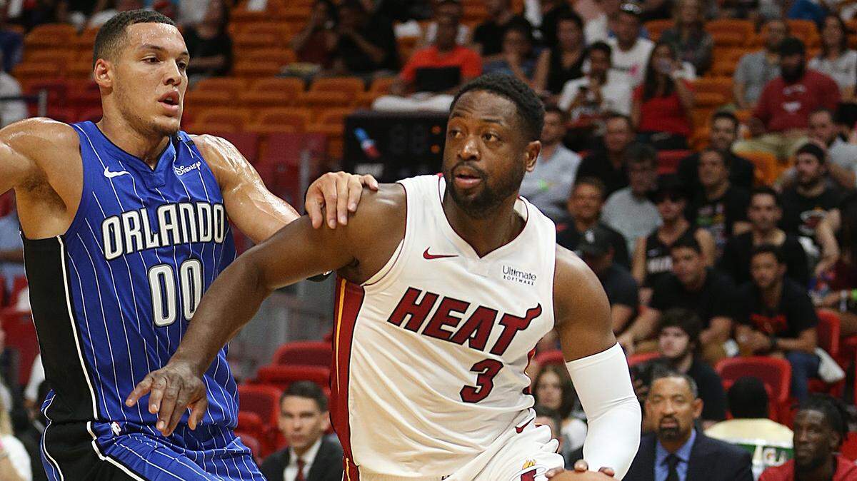El escolta del Heat Dwyane Wade (der.) entra al aro ante la marca de Aaron Gordon, del Magic, en un partido de pretemporada, el 10 de octubre de 2018.