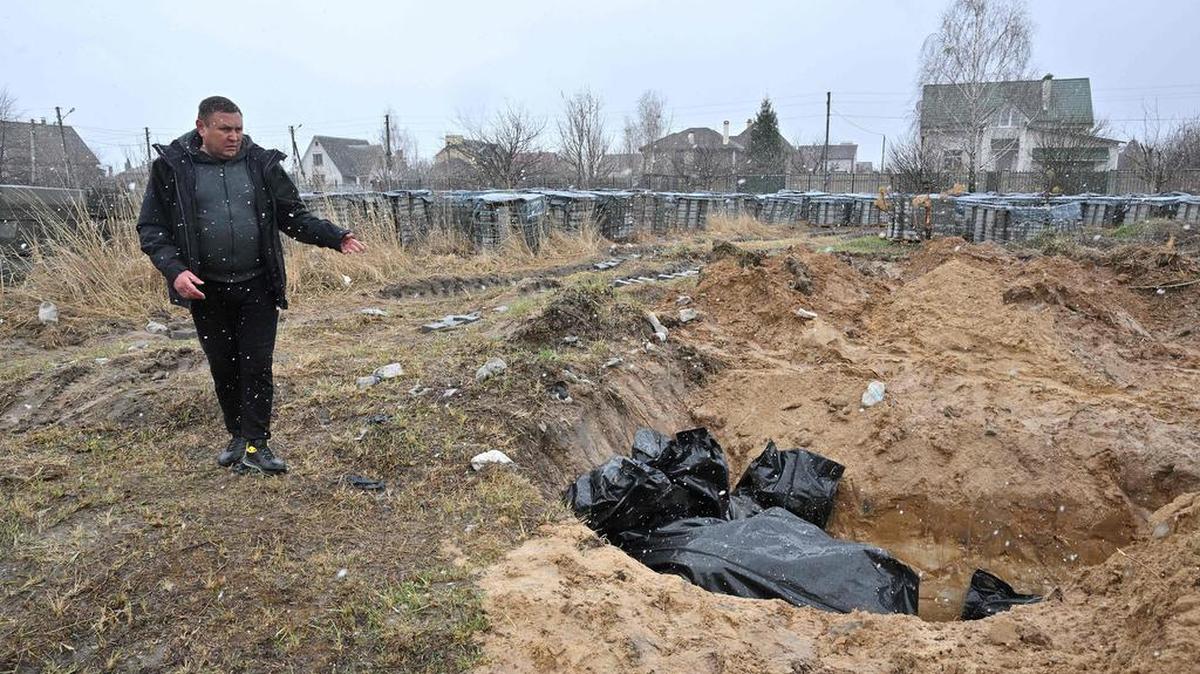 A man gestures at a mass grave in the town of Bucha, northwest of the Ukrainian capital Kyiv on April 3, 2022. (Sergei Supinsky/AFP via Getty Images/TNS)