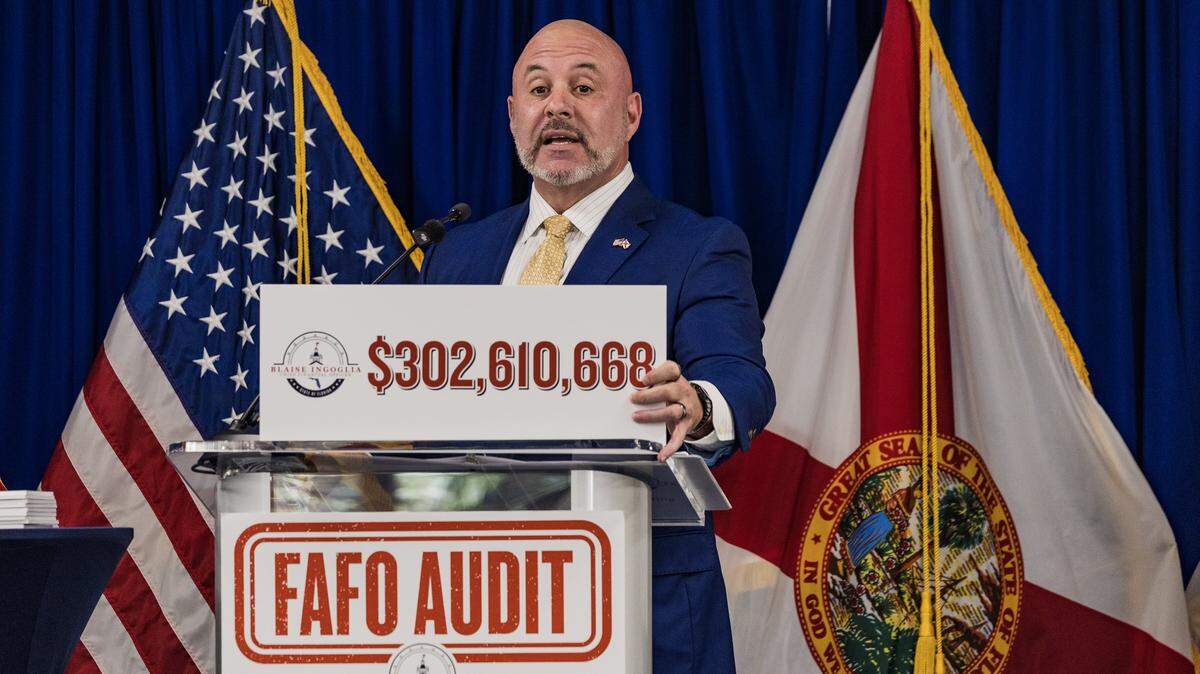 El director financiero de Florida, Blaise Ingoglia, sostiene un cartel que muestra la cantidad de dinero que, según él, el condado de Miami-Dade gastó de más en su presupuesto de 2025 en una conferencia de prensa en FIU el pasado jueves.