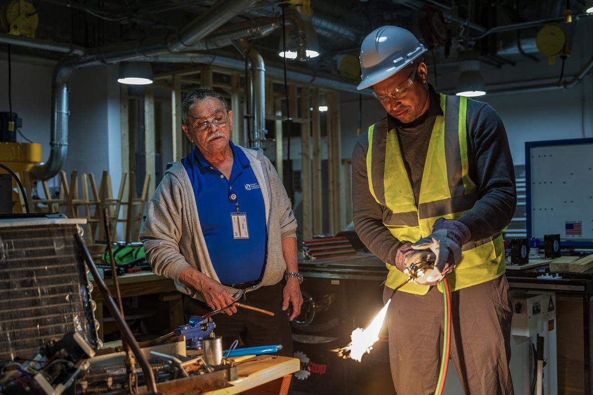 Instructor Omar Silva supervises as student Reinier Colas fires up a torch to solders an ac unit coil copper lines, during a nHVAC/R Technician Certificate Program class, at Miami Dade College North Campus, in North Miami, on Thursday, February 05, 2026.