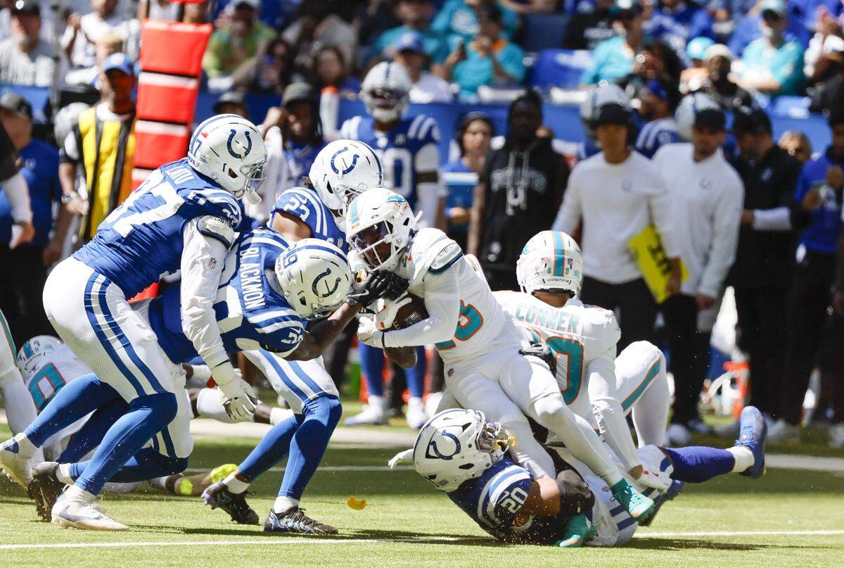 El running back De'Von Achane (28) es derribado por el safety Nick Cross (20), de los Colts, en el partido celebrado el 7 de septiembre de 2025 en el Lucas Oil Stadium en Indianápolis, Indiana.