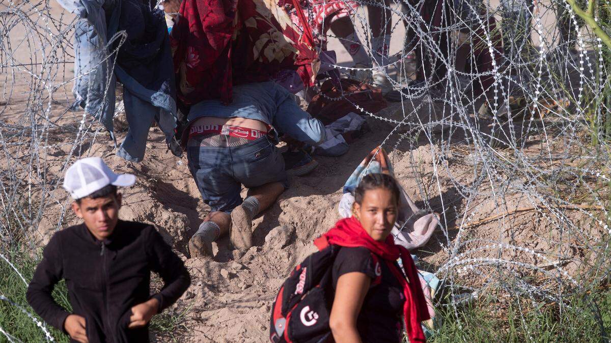 Migrantes rompen el alambre de concertina colocado por la Guardia Nacional de Texas en la frontera entre Ciudad Juárez y El Paso, Texas, el 20 de septiembre de 2023.