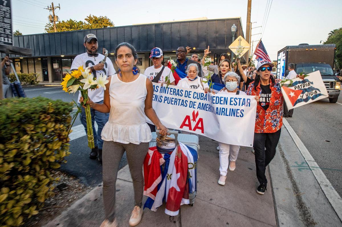 Cuban exiles joined activist Anameli Ramos (front) who is stranded in Miami after she was denied boarding an AA flight to Havana, during a pacific march from the Cuban restaurant Versailles to the American Airlines offices in Coral Gables, on Friday February 18, 2022,