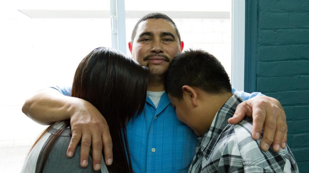 El inmigrante Salvadoreño Oscar Zavaleta (c) abraza a sus hijos María y Carlos este jueves 10 de diciembre de 2015, en Los Ángeles, Calfornia (EE.UU.). Después de años de amenazas por parte de pandilleros, tres menores salvadoreños lograron emigrar legalmente a Estados Unidos y reunirse con su padre, Oscar Zavaleta, gracias al Programa de Refugiados para Niños Menores Centroamericanos (CAM).