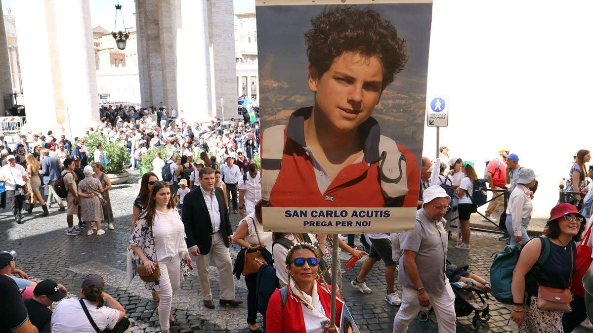 Fieles con el estandarte de Carlo Cutis caminan hacia la Plaza de San Pedro, el domingo 7 de septiembre de 2025, en la Ciudad del Vaticano.