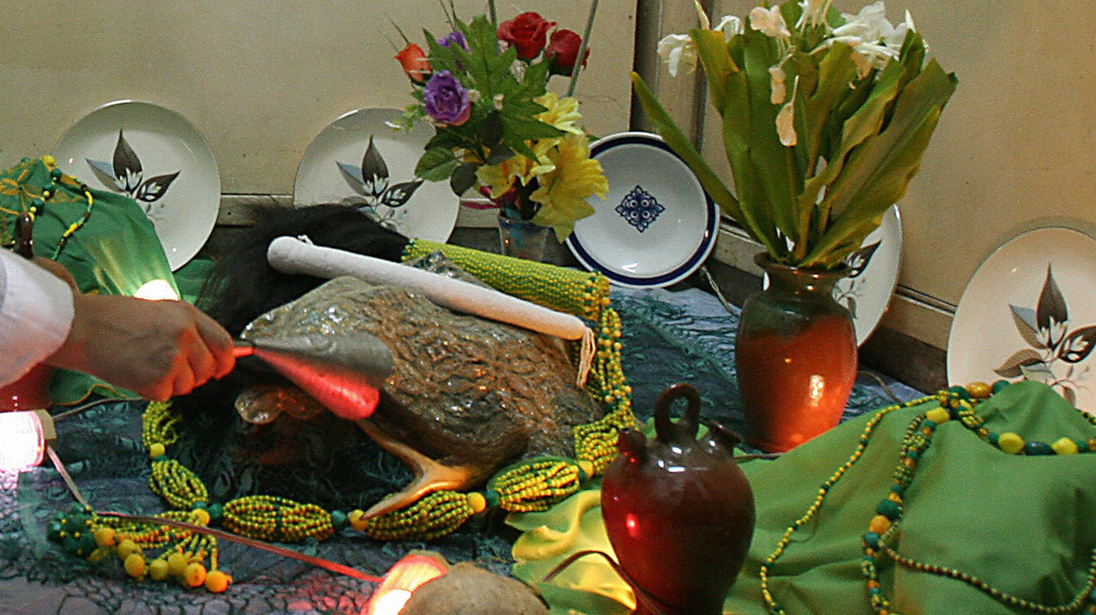 Una persona toca una campana en un altar de orishas yoruba durante una ceremonia de iniciación el 7 de octubre de 2006 en un templo-hogar de santería en La Habana.