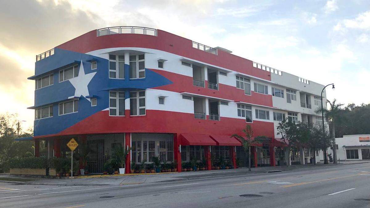 La fachada del restaurante La Placita está cubierta por un gigantesco mural de la bandera puertorriqueña realizado por el artista boricua Héctor Collazo Hernández..