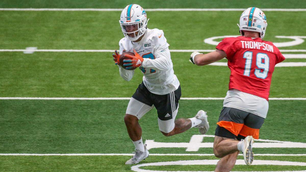 El quarterback de los Dolphins, Skylar Thompson (19), pasa el ovoide al running back Myles Gaskin, durante la práctica celebrada el 30 de agosto de 2022 en el Baptist Health Training Complex en Miami Gardens, Florida.