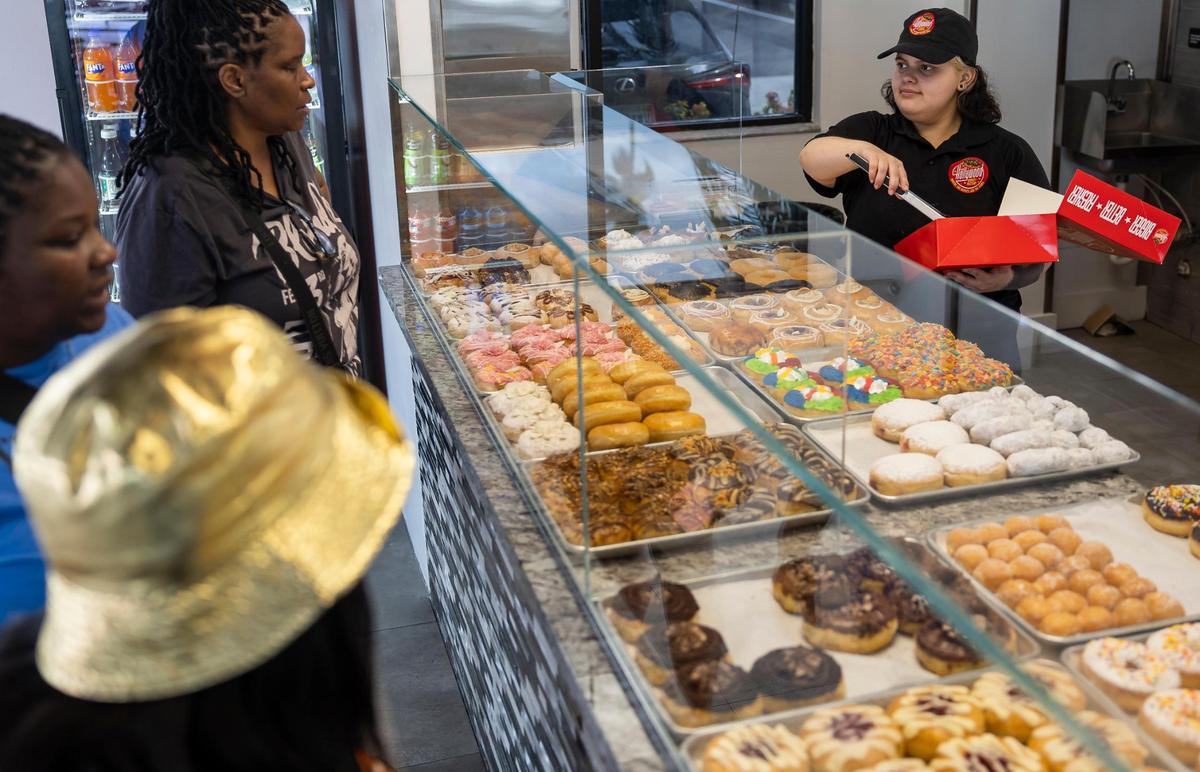 Elizabeth Alvarado, de 22 años, empleada de Hollywood Donut Factory, ayuda a los clientes con un pedido en la tienda de Bird Road.