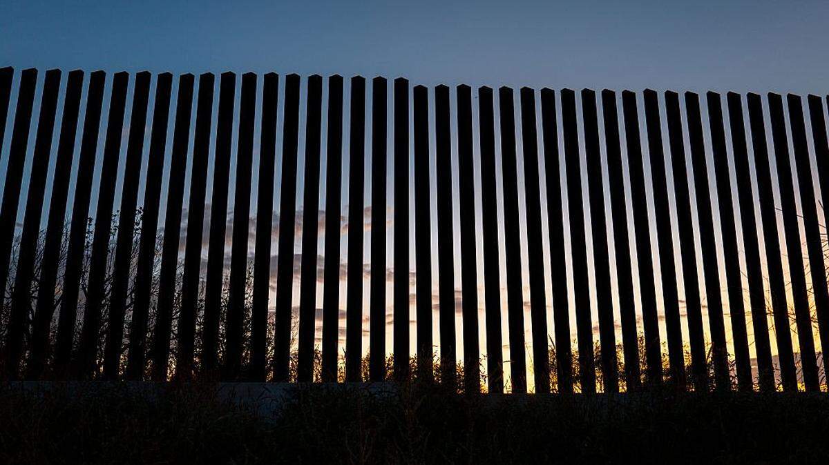 EAGLE PASS, TEXAS - OCTOBER 14: The sun sets behind a section of border fencing on October 14, 2025 in Eagle Pass, Texas. The Department of Homeland Security has announced that the federal government will be awarding 10 construction contracts worth more than $4 billion that will expand barriers along the U.S southwest border by 230 miles. The contracts will seek to implement extra security measures including lights, cameras, steel barriers and various detection technologies. (Photo by Brandon Bell/Getty Images)
