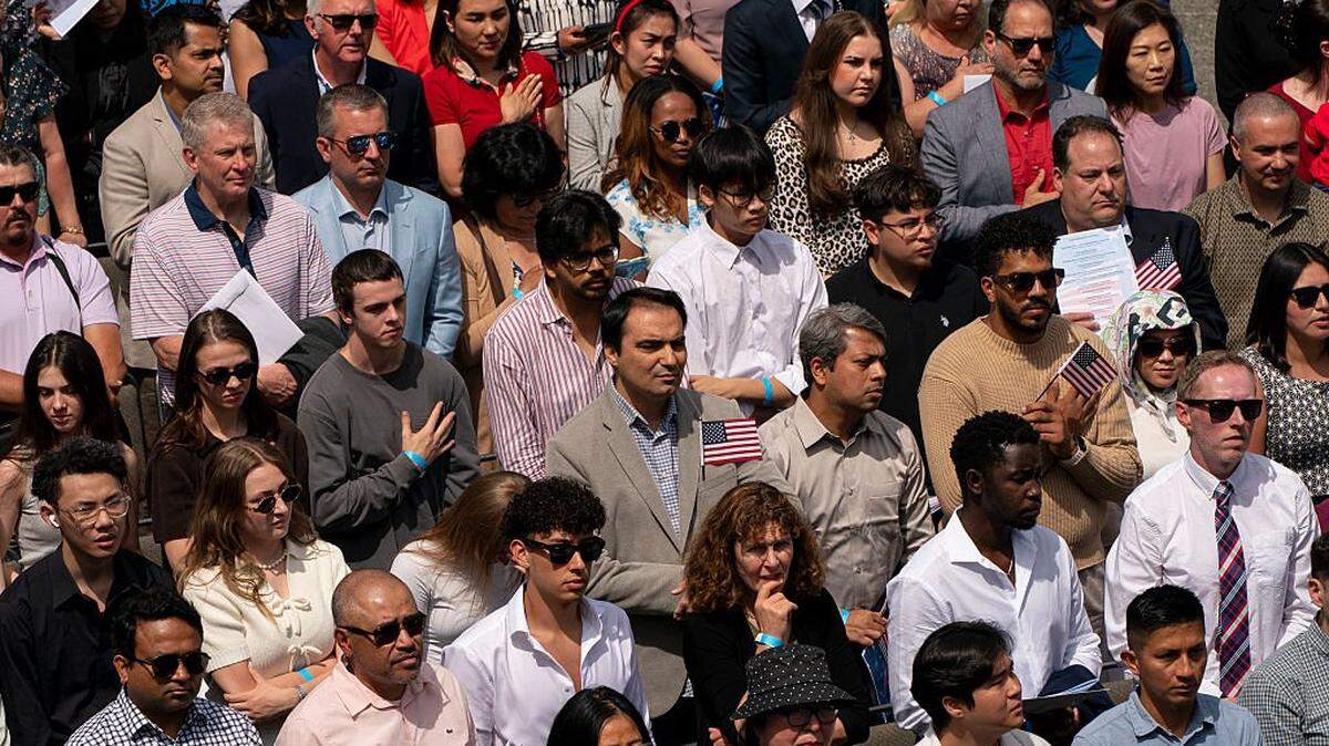 SEATTLE, WASHINGTON - JULY 04: Participants listen to the national anthem during a naturalization ceremony for new U.S. citizens at Seattle Center on July 4, 2025 in Seattle, Washington. The annual event drew hundreds of participants from approximately 80 countries. (Photo by David Ryder/Getty Images)