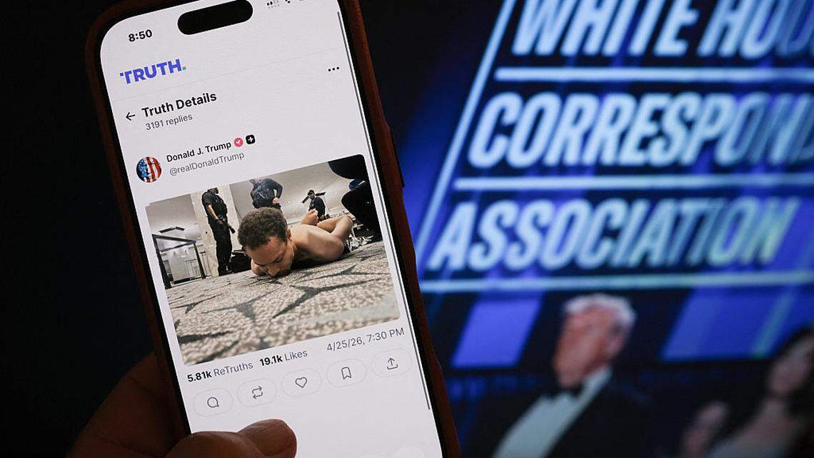 Esta fotoilustración muestra un teléfono con una publicación de Truth Social del presidente Donald Trump, en la que aparece una imagen del sospechoso de un tiroteo durante la Cena de Corresponsales de la Casa Blanca, en Washington DC, tendido en el suelo tras ser detenido, el sábado 25 de abril de 2026.