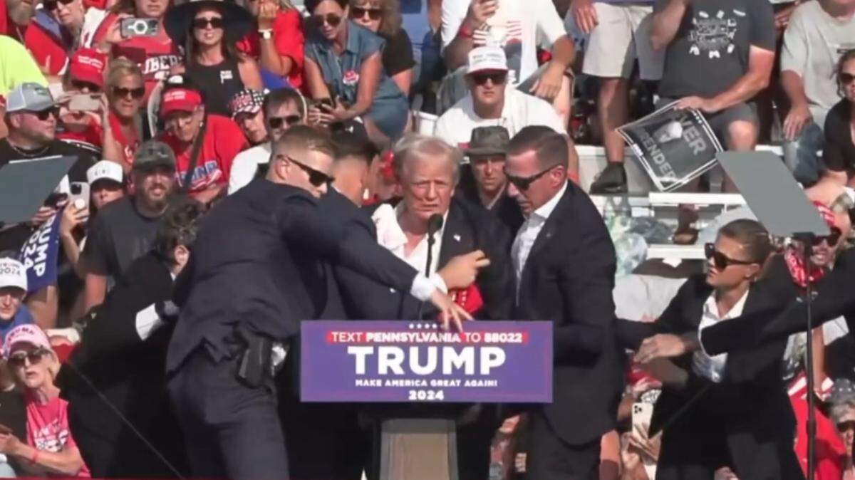 El expresidente Donald Trump es rodeado por agentes del Servicio Secreto tras sufrir un atentado en un mitin de campaña en Butler, Pensilvania, el 13 de julio de 2024.